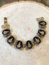 Load image into Gallery viewer, Vintage 1960s Gold Tone &amp; Black Reverse Glass Buddhist Meditation Goddess Namaste Panel Link Bracelet 7.5”

