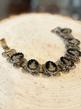 Load image into Gallery viewer, Vintage 1960s Gold Tone &amp; Black Reverse Glass Buddhist Meditation Goddess Namaste Panel Link Bracelet 7.5”
