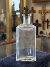 Load image into Gallery viewer, Antique 1910s Edwardian Clear Glass Holy Water Bottle Cross &amp; Leaves with Metal Crown Cap 6” Tall
